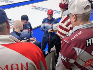 The United States' John Shuster, center, signs autographs for fans with teammates Colin Hufman and Chris Plys following a game at the 2026 World Men's Curling Championship on Saturday, March 28, 2026, in Ogden, Utah. (Ryan Olson, Standard-Examiner)